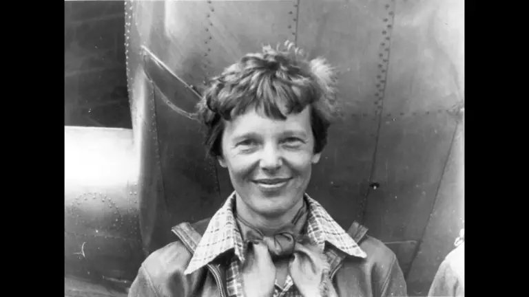 Amelia Earhart standing under nose of her Lockheed Model 10-E Electra