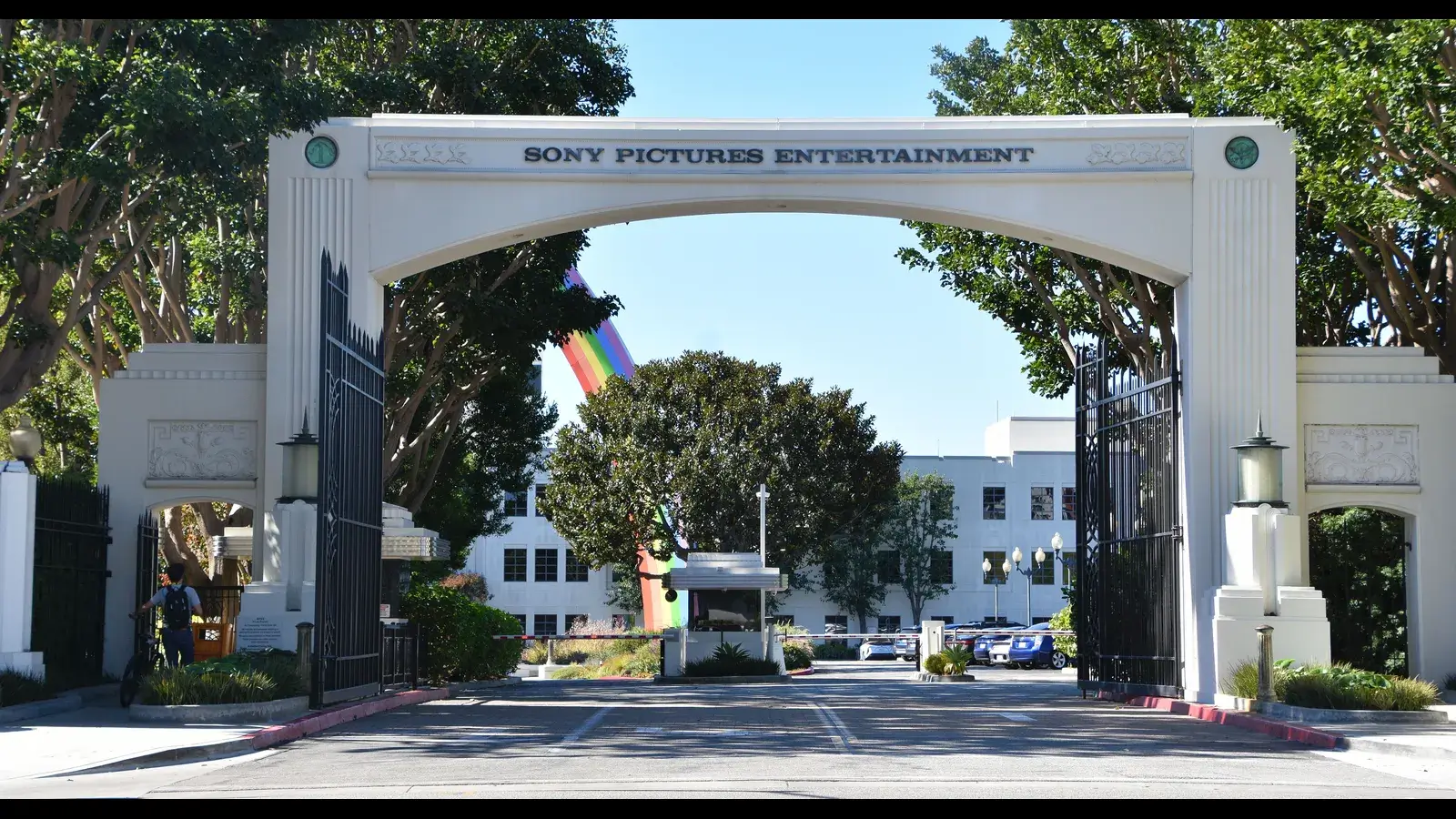 Sony Pictures Entertainment entrance gate with trees and a rainbow flag in view. Sony Pictures Television executives