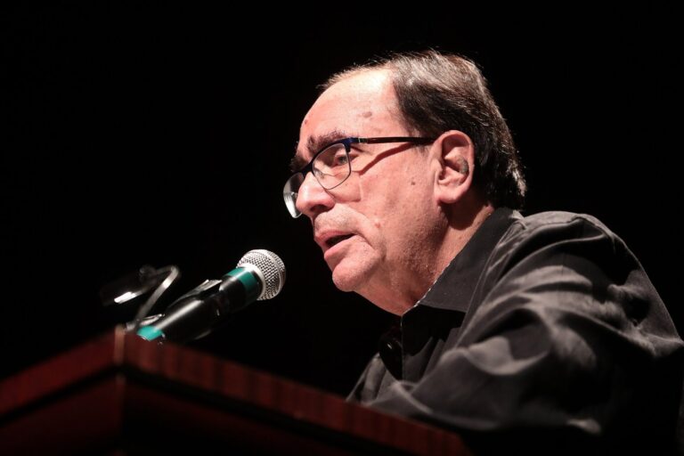 Author R.L. Stine, whose Afraid of Clowns movie is headed to Tubi, speaks at a microphone during a 2019 event in Phoenix