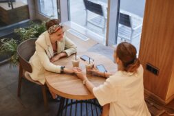 Friends talking in a coffee shop, one way to cope with loneliness through connection