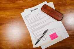 Divorce papers with a pen and a ring on a wooden desk, illustrating the Gabe Brown divorce
