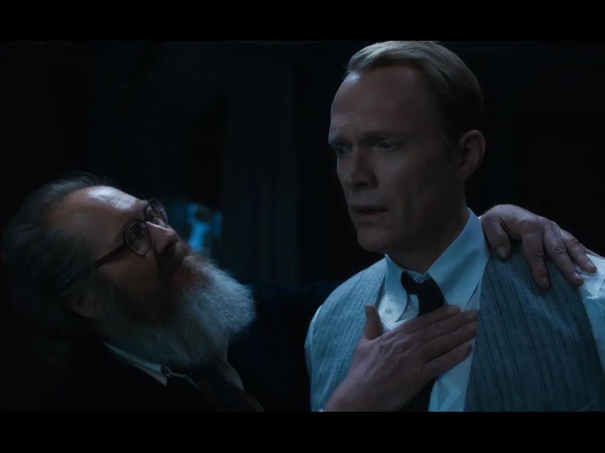 . James Spader with glasses and a beard talks to Paul Bettany in a scene from "VisionQuest" (2026).