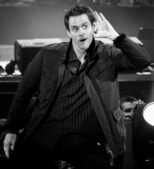 Jim Carrey cups his ear on stage at the Premios 40 Principales in Madrid in 2008, years before Jim Carrey married Min Ah