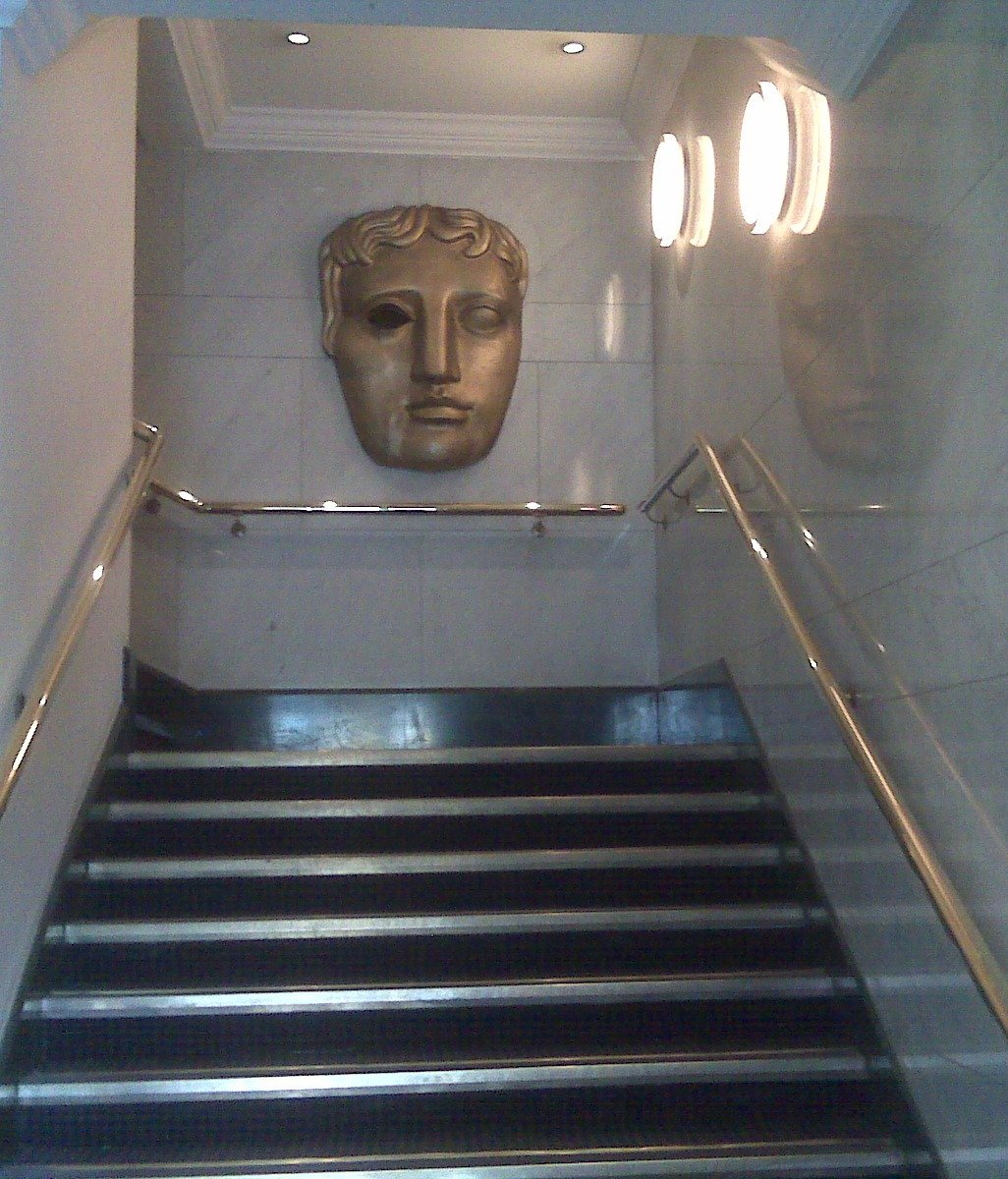John Davidson BAFTA story: the bronze BAFTA mask mounted above a staircase at BAFTA headquarters on Piccadilly in London