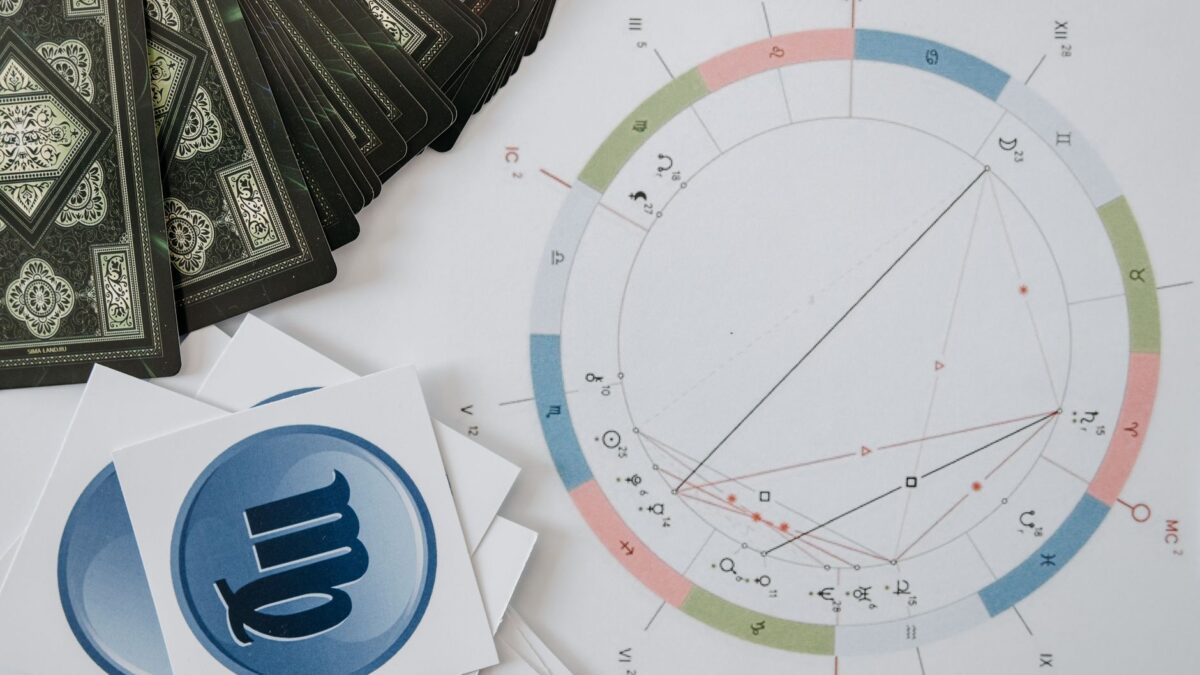 Tarot cards and a horoscope on a table for Venus and Mercury retrograde