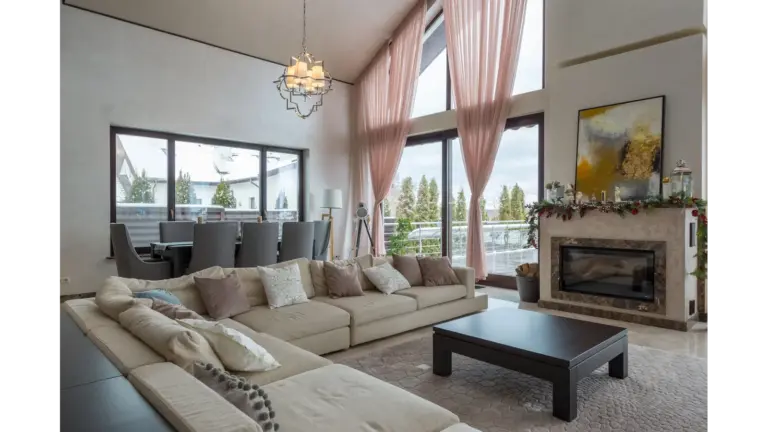 Spacious living area featuring modern decor, cozy seating, and a fireplace, showcasing Cozy Winter Decor for a warm and inviting atmosphere perfect for relaxation.