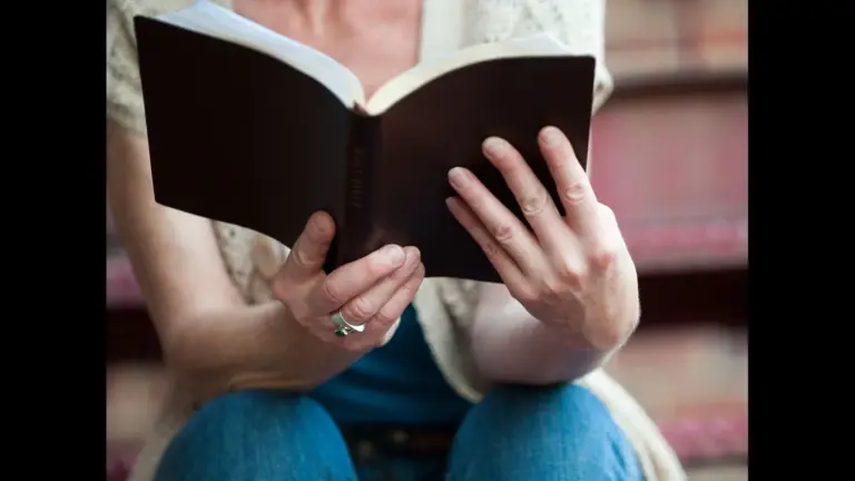 In Friday's daily devotional, a woman holds the Bible up and reads it during her study time.