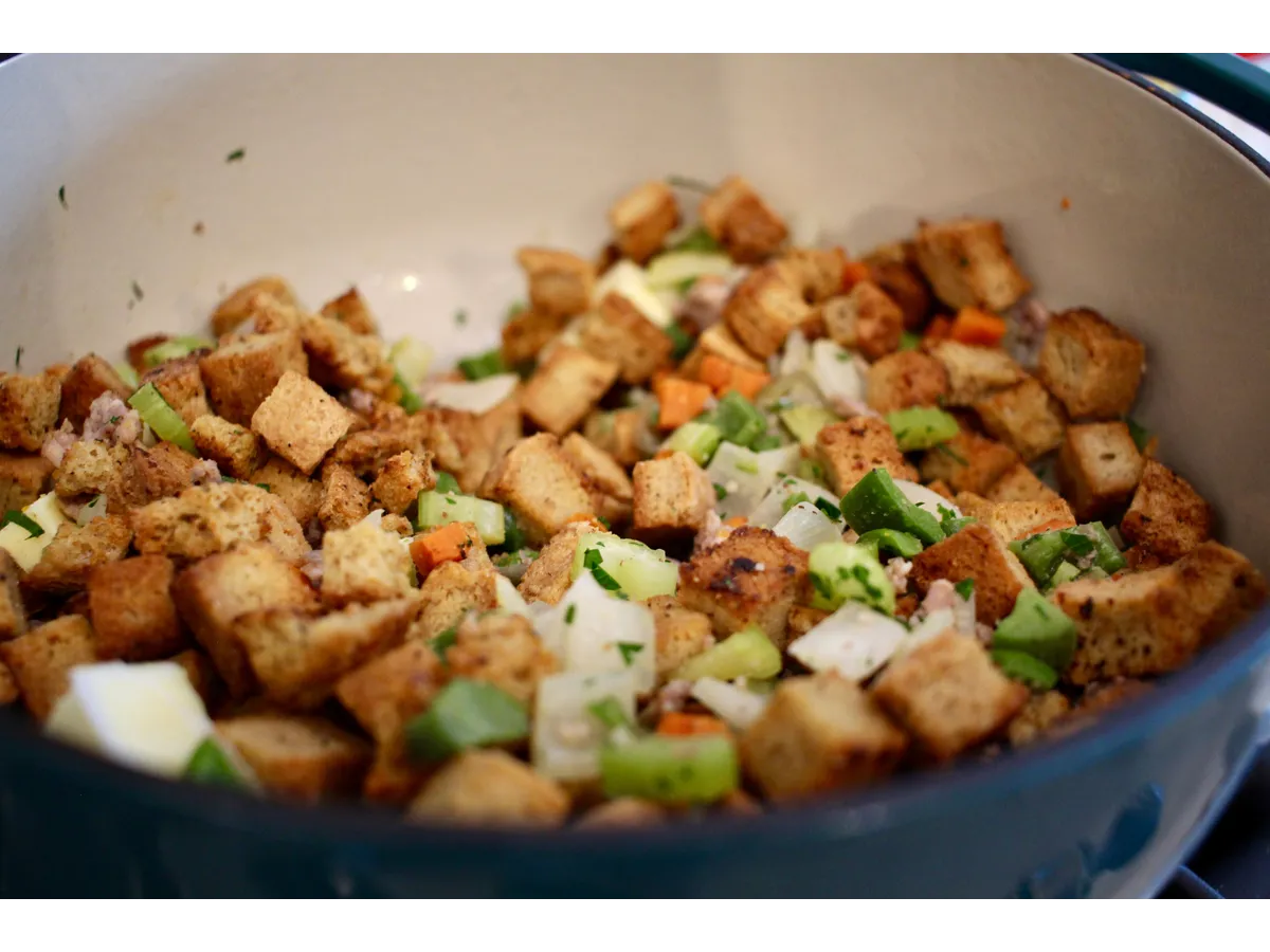 Delicious homemade stuffing with fresh vegetables in a ceramic pot, making easy Thanksgiving recipes even more inviting and flavorful.
