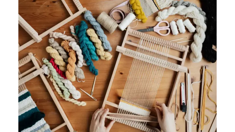 Hands weaving colorful yarn on a loom indoors, showcasing craftsmanship, creativity, and the inspiring journey behind many DIY success stories.
