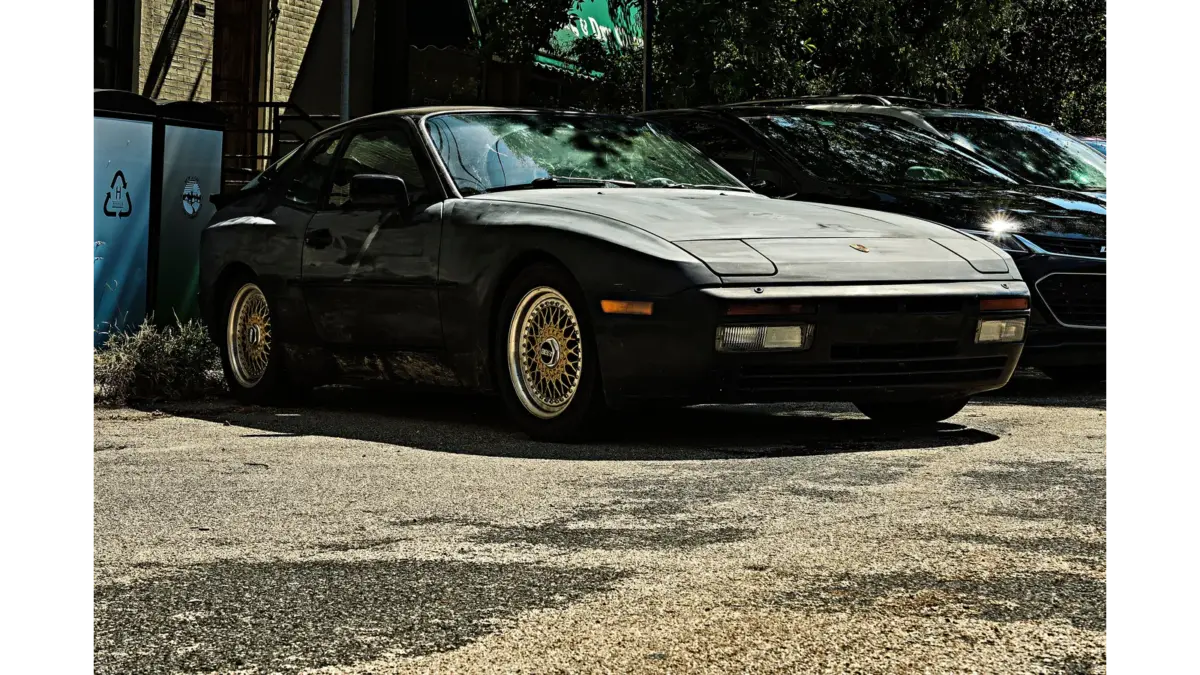 A sleek black vintage car parked outdoors, highlighting its retro styling and classic lines as part of a Porsche conversion theme.