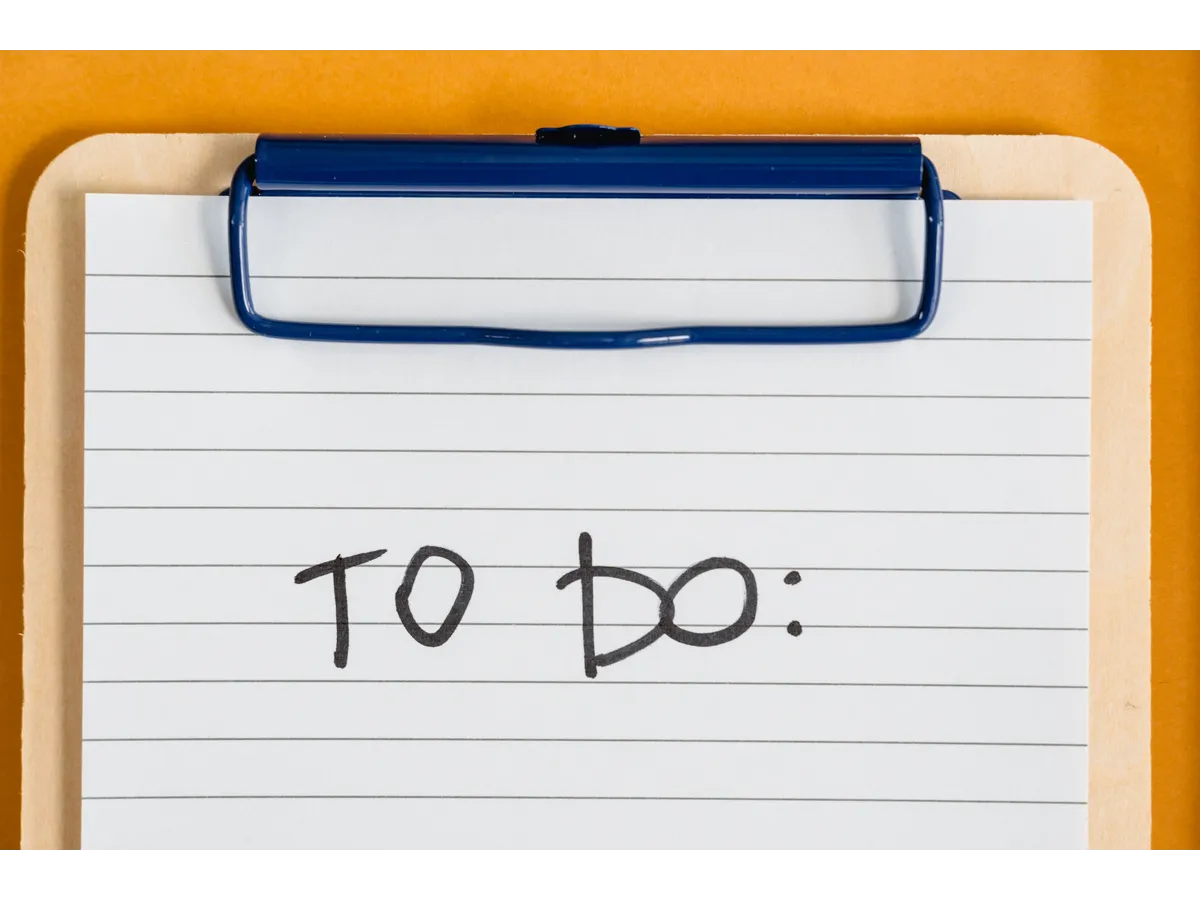 Clean and simple image of a to-do list on a clipboard with lined paper, illustrating an easy way to reduce decision fatigue through planning and task organization.