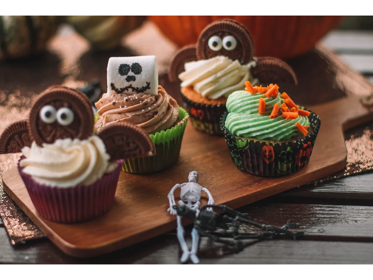 Spooky Easy Halloween Cupcakes with creative ghost-themed decorations displayed on a wooden table during festive Halloween baking.