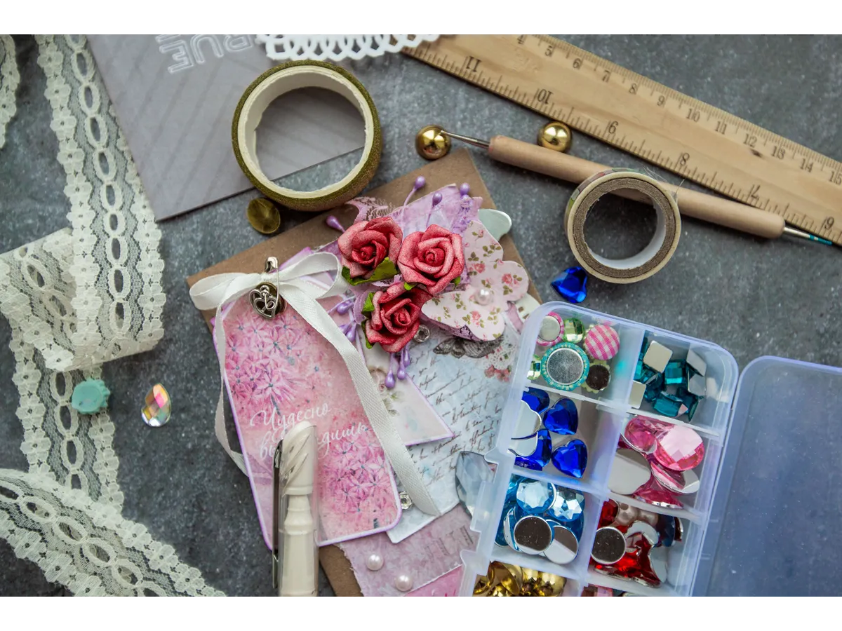 A vibrant flat lay of craft supplies including lace, beads, and handmade cards, perfect for designers exploring creative dollar crafting projects.