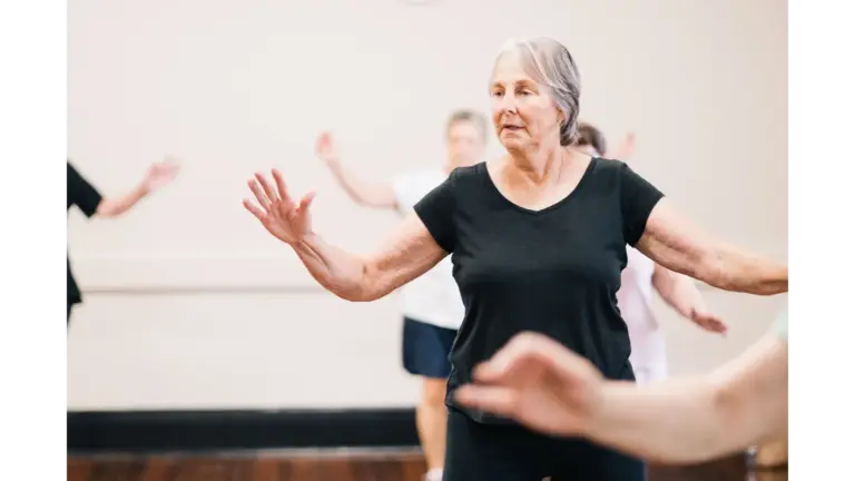 Older woman participating in a group fitness class, practicing slow, controlled movements that reflect longevity science secrets and healthy aging.