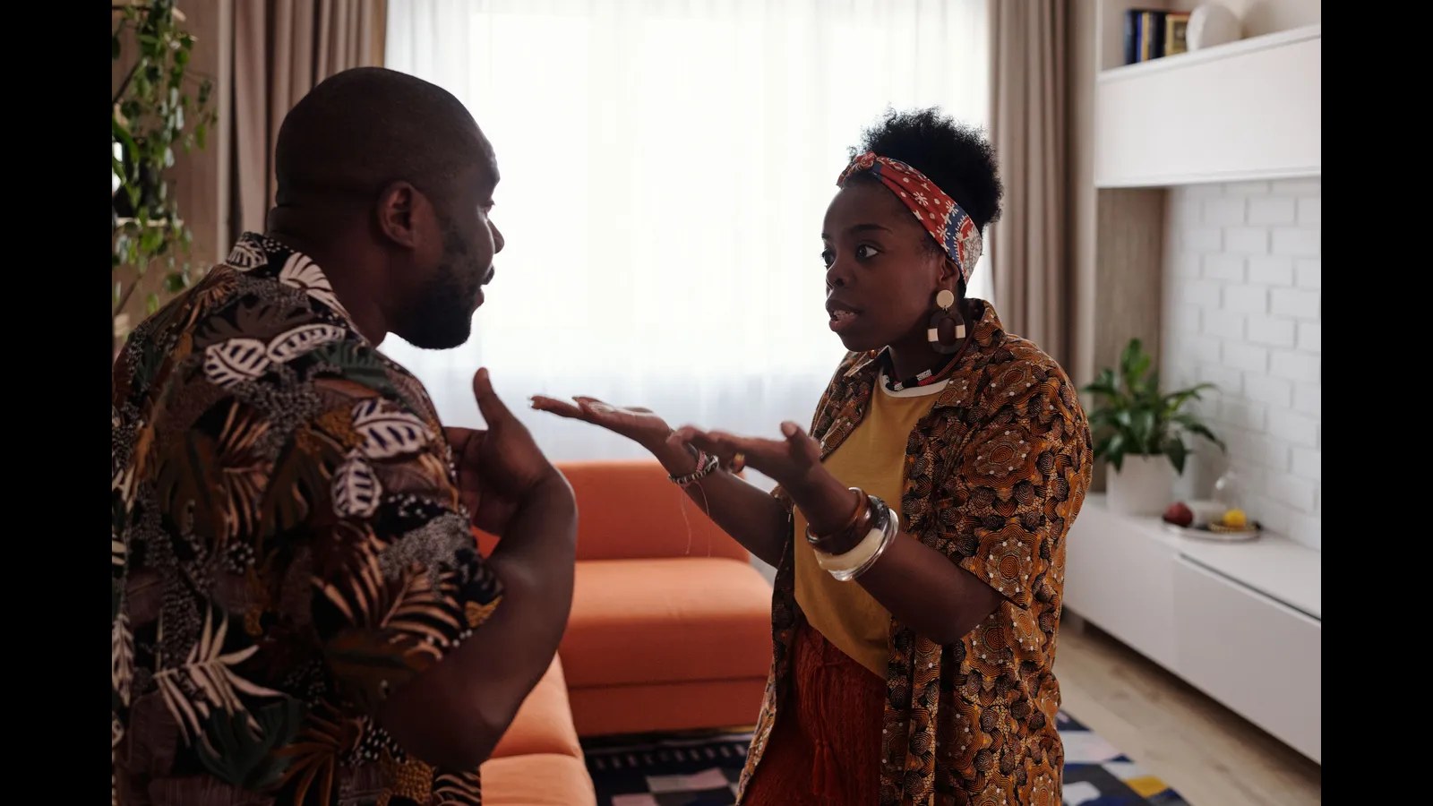 A couple argues in their living room, a moment of relationship conflict that a pause could help cool down