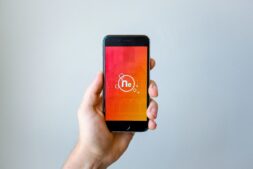 A hand holds a smartphone, the device many readers use for comics apps hit by the Tapas shutdown